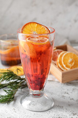 Glass of cocktail with berries and dried citrus fruits on grunge background