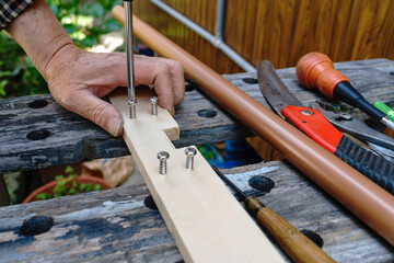 DIYをするシニア。ネジと プラスドライバー。作業。年配。