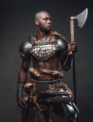 Powerful and handsome authentic soldier wearing armor with axe