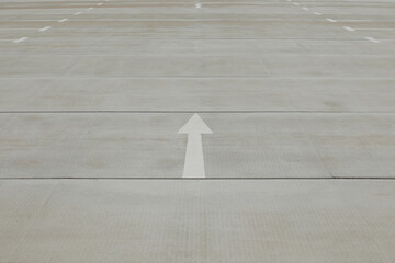 Street with white painted arrow, arrow sign on the floor, no person 