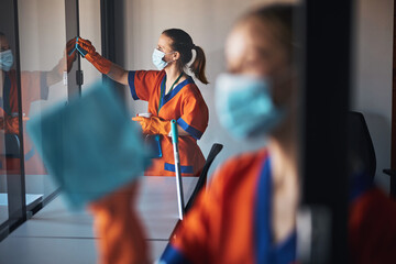 Janitorial staff washing the office glass walls