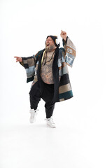 Fat stylish bearded tattoed caucasian man with big belly is posing and dancing wearing ethnic kimono