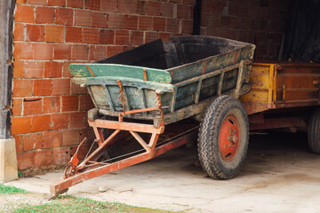 Une vieille remorque en bois dans un garage de brique. Des anciens véhicules agricoles. De...