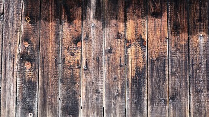 country style background of street wood surface of dried knotty gray planks illuminated by the sun dark textured wood surface of a rustic barn or barn wall