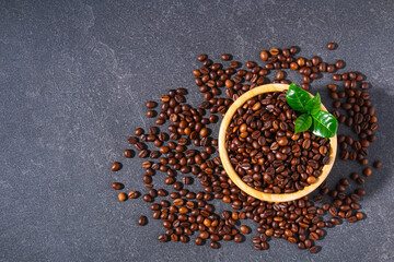 Roasted brown coffee beans on a gray background. Coffee beans in wooden bowls. Top view.