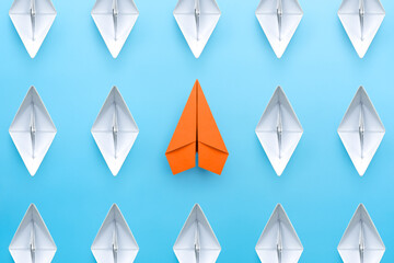 Orange paper plane standing out from the group of white paper boats, Business concept for new ideas creativity and innovative solution