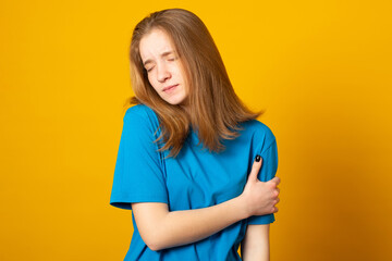 Cute girl suffering from arm pain, painful in arm muscles.