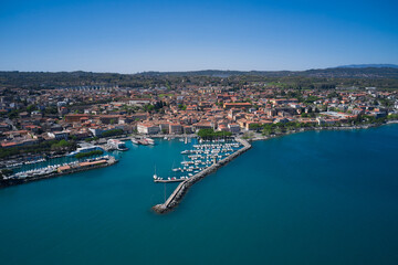 Fototapeta premium Aerial panorama of Italian cities. Aerial view of the coastline of the city of Desenzano del Garda on Lake Garda, Italy. Desenzano del garda port.