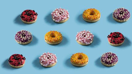 Fototapeta na wymiar Different donuts decorated with colourful icing and sprinkles on light blue background. Creative pattern design.