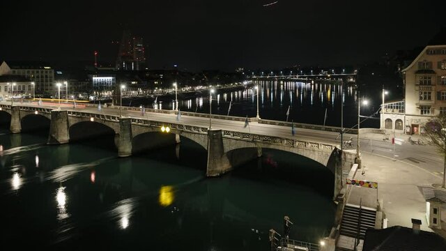 Basel Mittlere Brucke (Middle Bridge) located in Basel city center, time lapse with flowing water and fast moving night traffic.