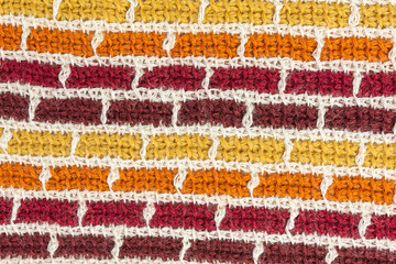 striped background of tunisian crochet fabric in basic stitch in shades of brown with grid pattern