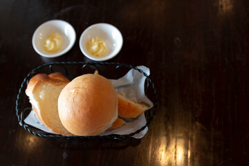 Bread in basket. Variety of homemade bread, in a metal basket on a wooden table. Variety of baking bread on wooden table with butter.