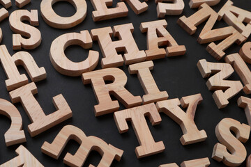 Charity, text words typography written with wooden letter on black background, life and business motivational inspirational