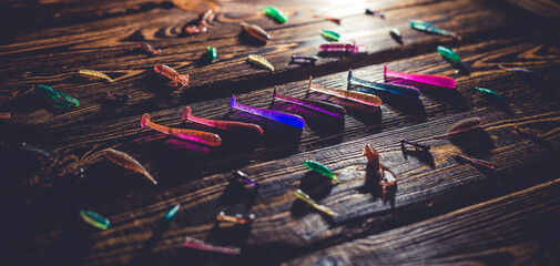 Silicone fish bait on a wooden background. Toned photo studio. © BearOK