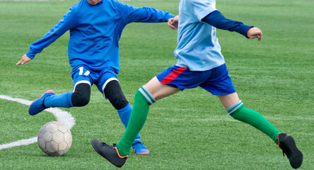 Children's football. An interesting football moment at the match and training. The active struggle and dynamics of the boys' soccer match. The boys are recklessly fighting for the ball