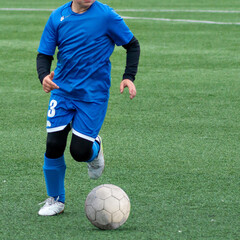 Children's football. An interesting football moment at the match and training. The active struggle and dynamics of the boys' soccer match. The boys are recklessly fighting for the ball