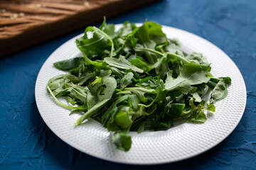 Fresh arugula salad on a plate. Concept of dieting or detox or vegetarian