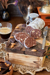 Chocolate salami on a wooden board on a wooden background. Side view.