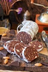 Chocolate salami on a wooden board on a wooden background. Side view.
