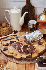 Chocolate salami on a wooden board on a wooden background. Side view.