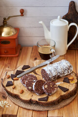 Chocolate salami on a wooden board on a wooden background. Side view.