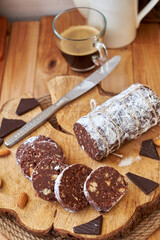 Chocolate salami on a wooden board on a wooden background. Side view.