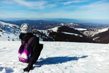 Fototapeta na wymiar Woman enjoying on a mountain winter fresh air.