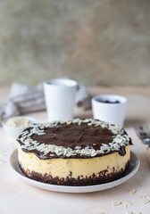 Delicious creamy cheesecake decorated with chocolate glaze and almond, light concrete background. No bake mousse dessert.