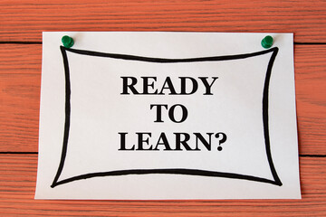 READY TO LEARN? - words on a white sheet on a brown wooden background