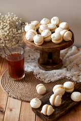 Homemade macaroons on wooden background with glass of tea