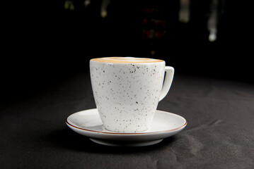 Cup of caramel latte coffee on black background. Delicious sweet sugar coffee