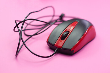 wired and red computer mouse in the photo with pink background. technology product photos
