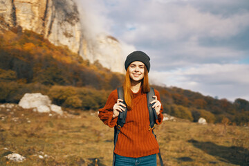 a traveler with a backpack in a denim hat are walking on the nature mountains