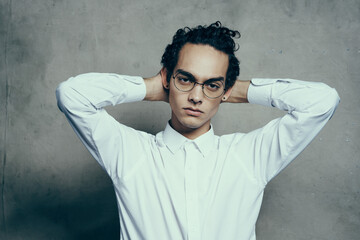 attractive young man wearing glasses white shirt straightens hair on his head portrait
