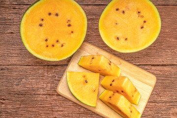 Yellow watermelon on the wooden background.