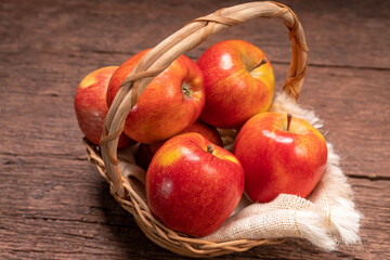 Envy Apple In a basket on a wooden floor.