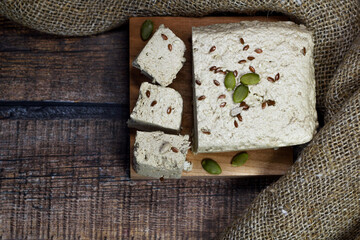 Halva close-up on a blackboard on a brown wooden background. Traditional oriental dessert sweet halva. Halva made from sunflower seeds. top view, flat lay, copyspace.