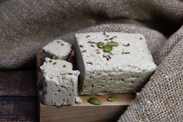 Halva close-up on a blackboard on a brown wooden background. Traditional oriental dessert sweet halva. Halva made from sunflower seeds. Side view, copyspace.