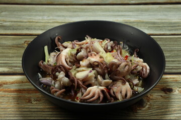 Pile of spicy squid or octopus salad serving on the plate. Famous appetizer menu in Asia restaurant. 
