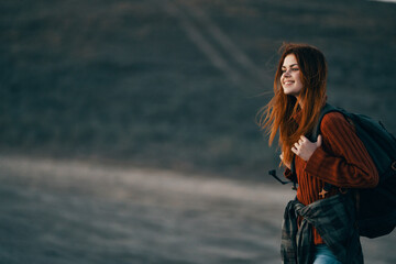 a woman in a theory family travels in nature in the mountains with a backpack on her shoulders