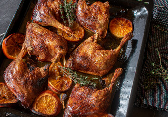 Roasted Duck legs with thyme, orange, honey sauce on a baking tray from above
