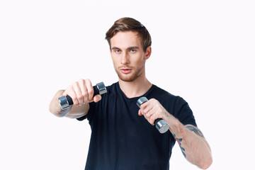 Fototapeta na wymiar athlete with dumbbells in his hands on a white background in a black t-shirt