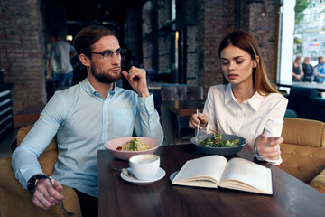 business men and women sit at the table with the phone chatting breakfast