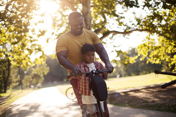 Funny ride.  African American father having fun outdoors with his son.
