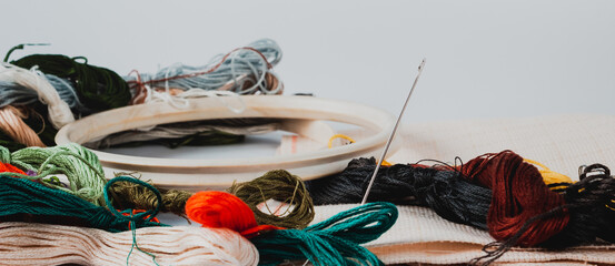 Accessories for embroidery: hoop, moulin, canvas and needle. The concept of needlework.