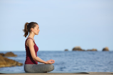Fototapeta na wymiar Profile of a woman doing yoga on the beach