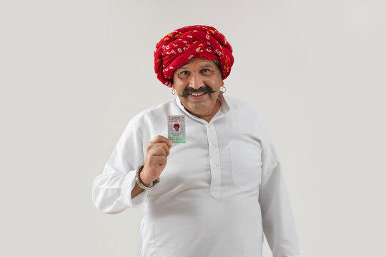 AN ADULT MAN WITH TURBAN HAPPILY SHOWING VOTER ID CARD	