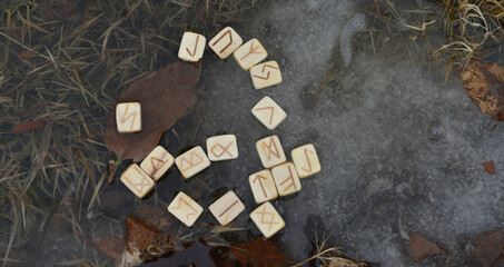 Wooden runes in the water, wiccan ritual with magic objects.  Esoteric, gothic and occult background, Halloween mystic and wicca concept outdoors.