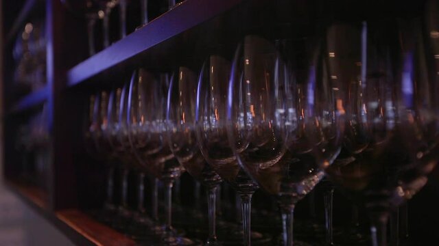 Push In Of Wine Glasses Lined Up On Shelf