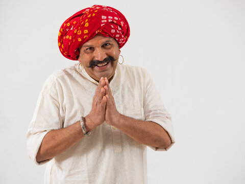 A HAPPY TURBANED VILLAGER GREETING WITH FOLDED HANDS - Powered by Adobe